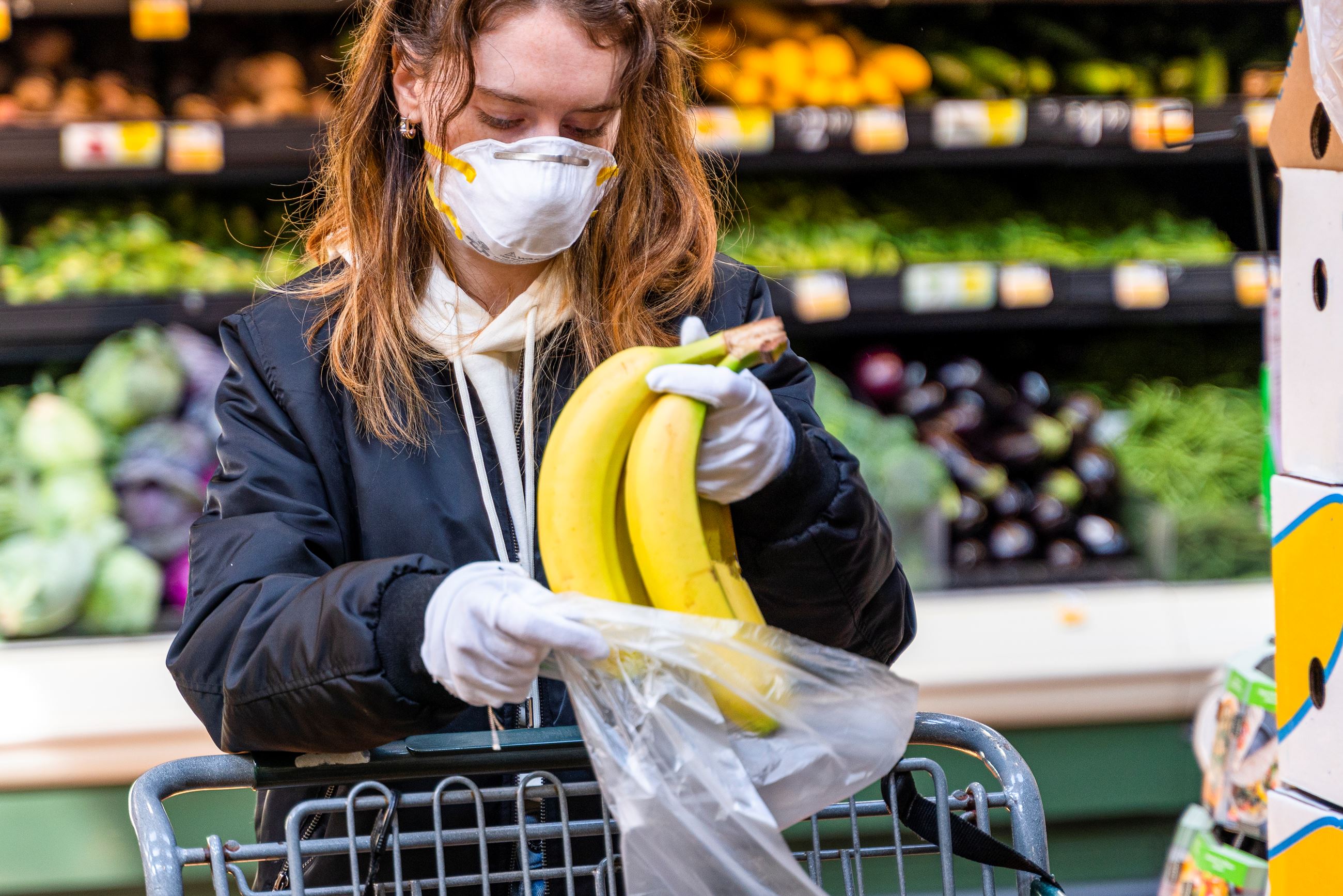 woman buying bananas in grocery store