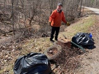 Man by the side of road with garbage bags