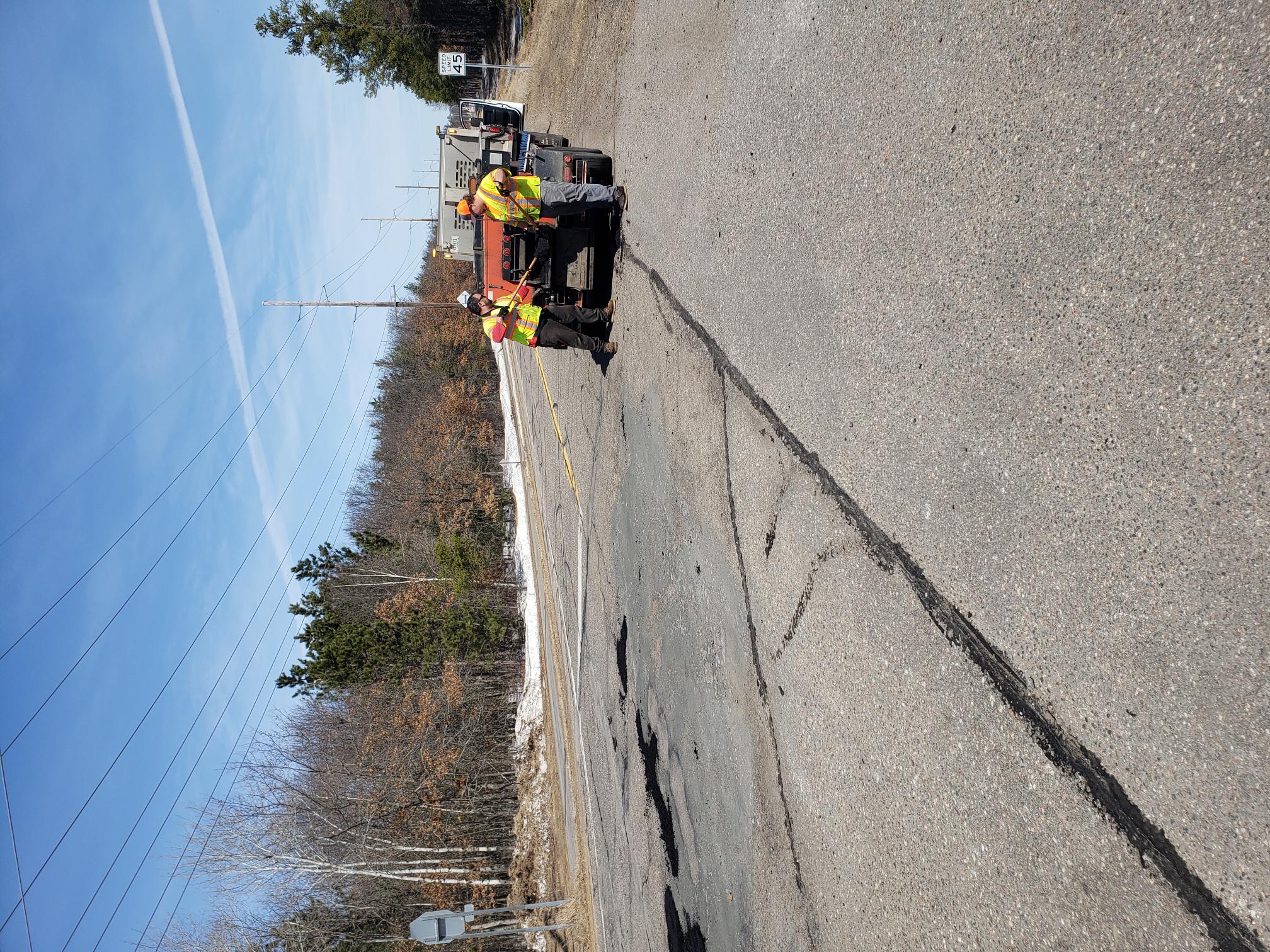 Road repair workers filling pot holes 